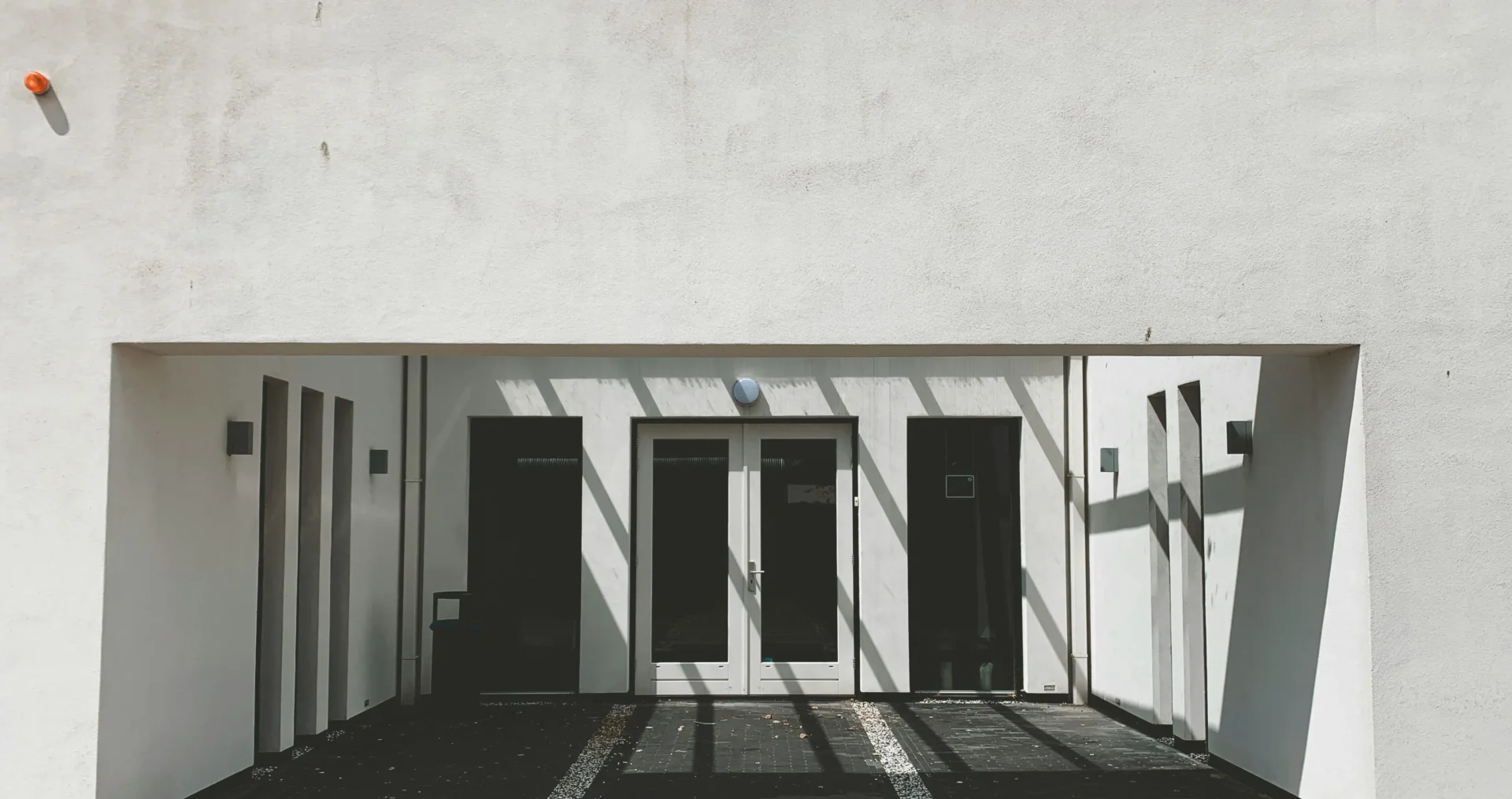 A building with two doors and a parking lot.