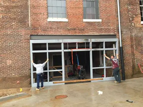 Two men are working on a building.