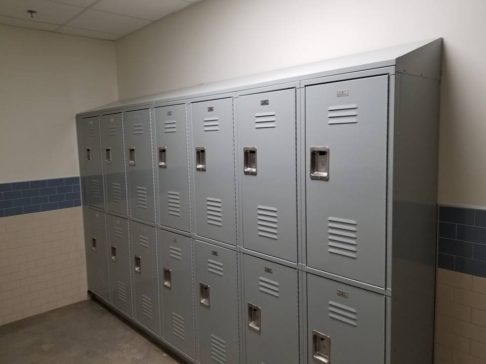 A row of lockers in a room with white walls.